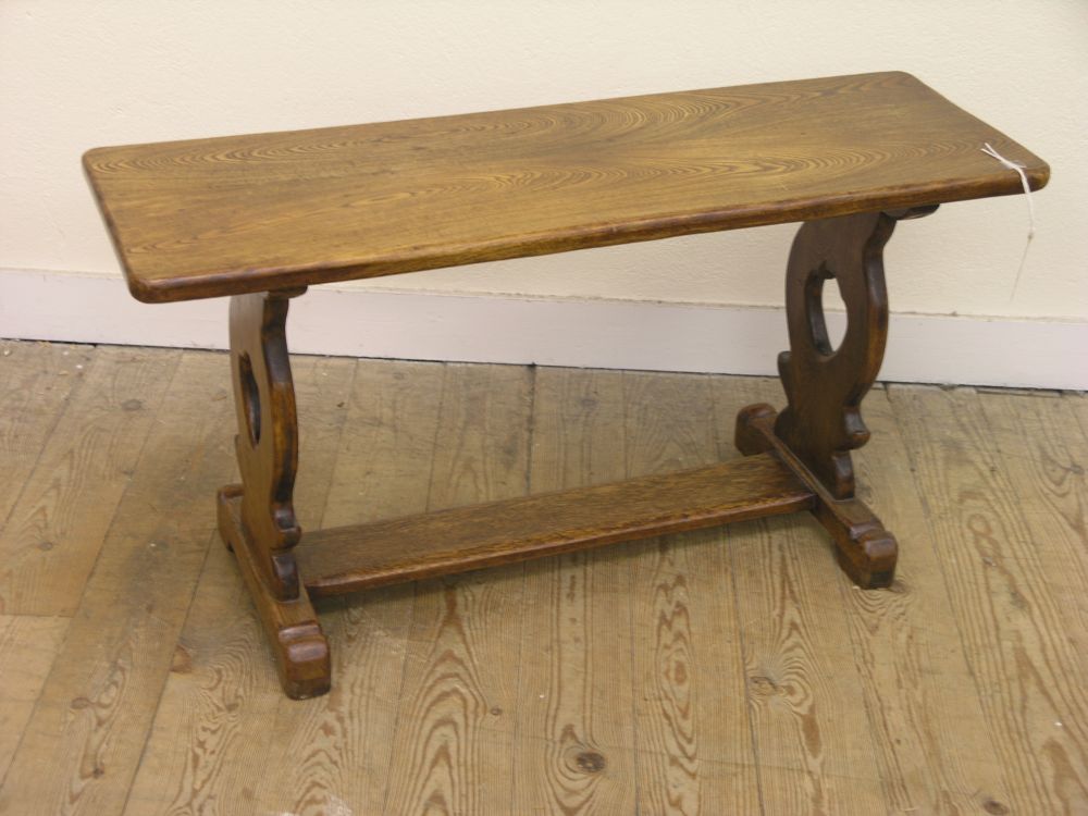 Appraisal: A solid oak long coffee table on pierced end supports