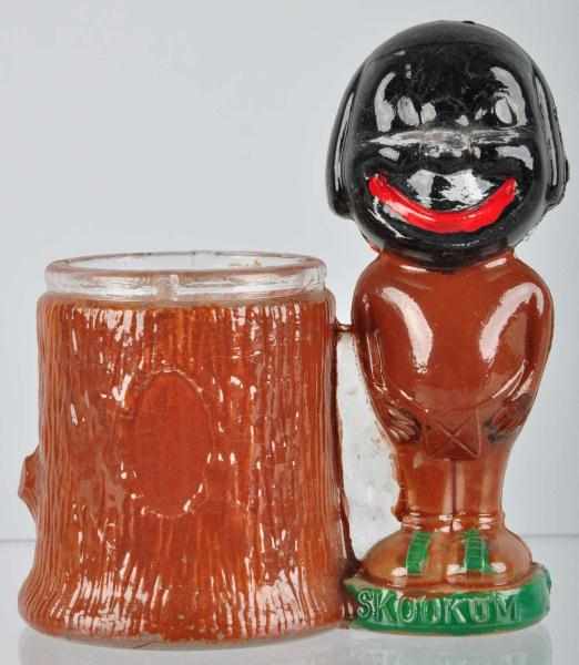 Appraisal: Glass Skookum Candy Container Description Skookum is standing beside a