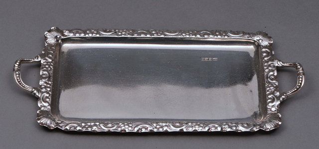 Appraisal: A SILVER RECTANGULAR RING TRAY with twin handles and embossed