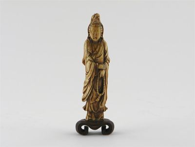 Appraisal: A Chinese ivory carving of Guanyin standing holding a bead