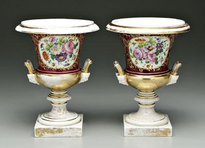 Appraisal: Pair Paris porcelain urns hand painted floral cartouches on aubergine