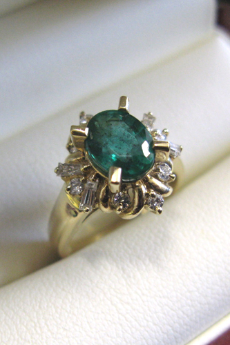 Appraisal: EMERALD DIAMOND FOURTEEN KARAT GOLD RING centering an oval-cut green