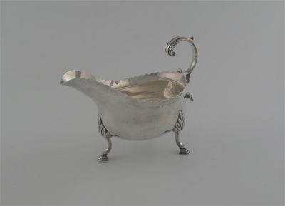 Appraisal: A George III sauceboat with scalloped rim scrolling handle on