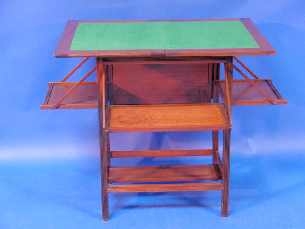 Appraisal: A late Victorian walnut folding card table with expanding shelves