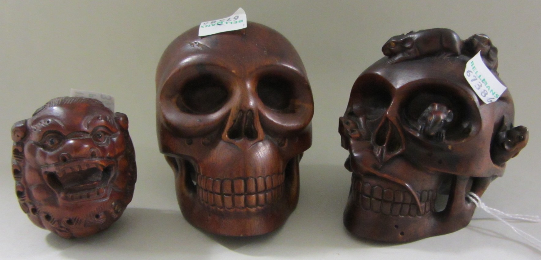 Appraisal: Two Japanese wood skulls one with rats and a serpent