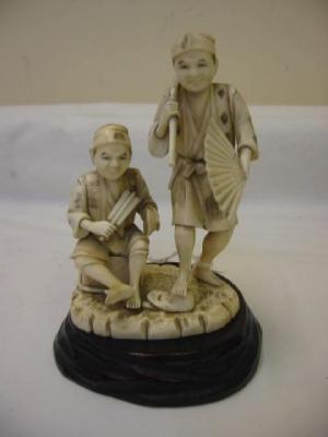 Appraisal: A CARVED IVORY OKIMONO modelled as two journeymen one seated