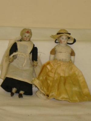 Appraisal: Two bisque head doll's house dolls with painted faces comprising