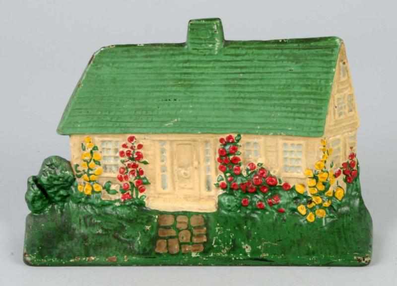 Appraisal: Cast Iron Cottage with Hollyhocks Doorstop Description National Foundry Condition