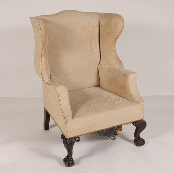 Appraisal: Upholstered Chippendale-style wingback chair carved claw and ball feet arched