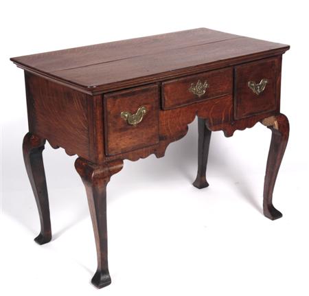 Appraisal: An th century oak and mahogany crossbanded lowboy the rounded