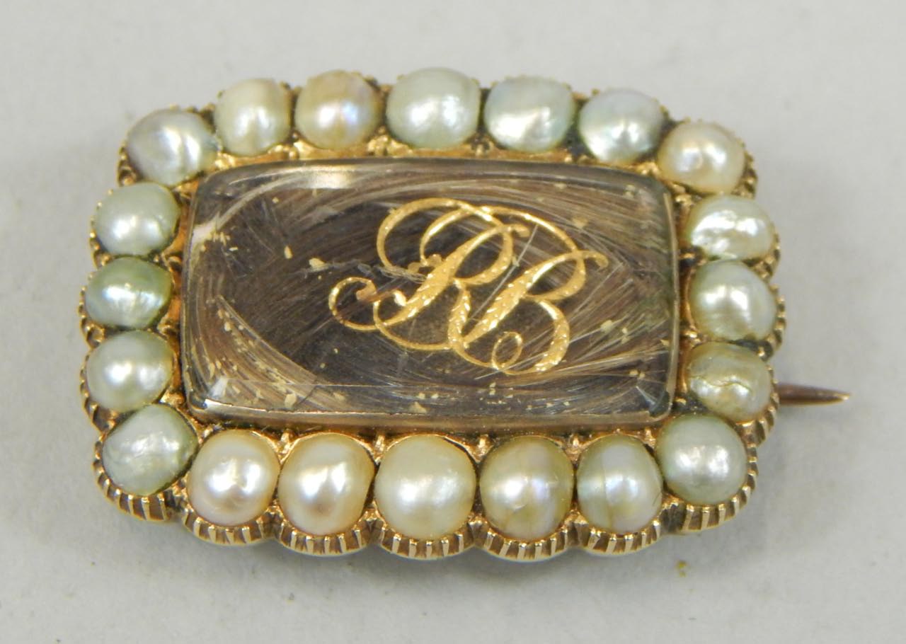 Appraisal: A Victorian memorial brooch with hair filled central window initials