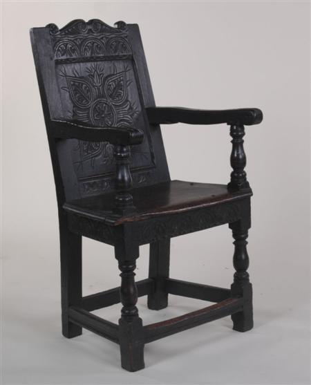 Appraisal: A th century oak carved hall chair the shaped top-rail