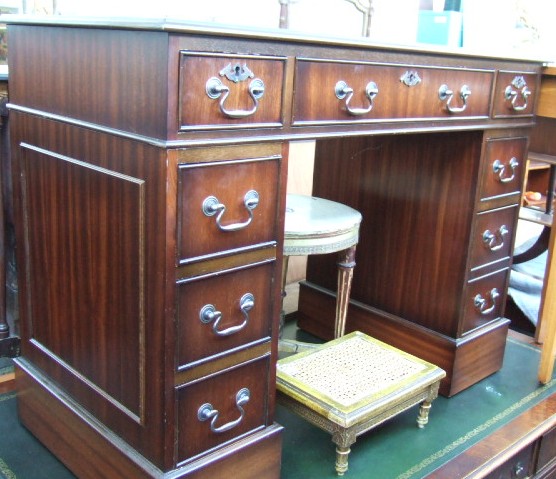 Appraisal: A reproduction mahogany pedestal desk with green tooled leather top