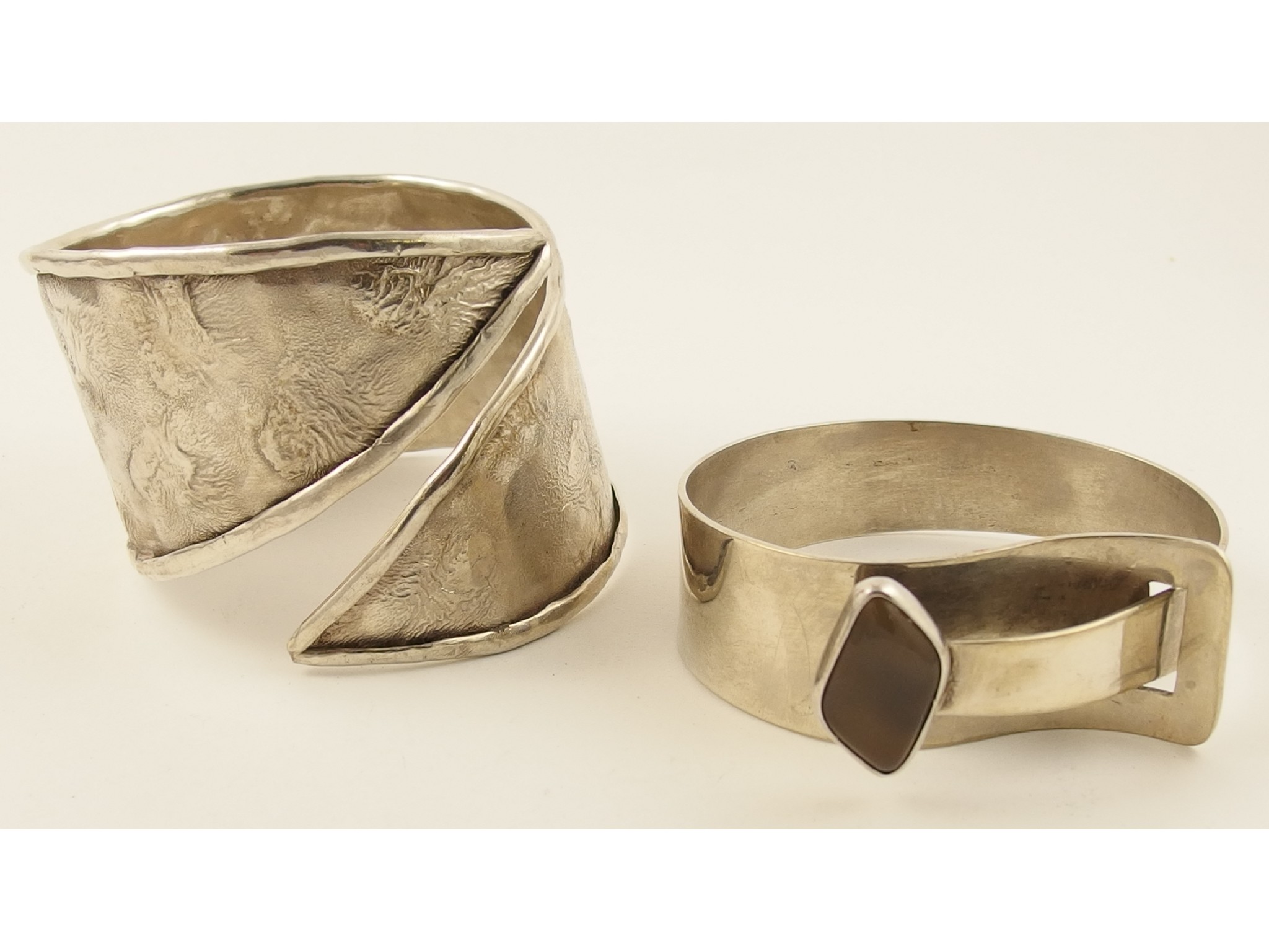 Appraisal: A heavy silver textured cuff bangle and another set with