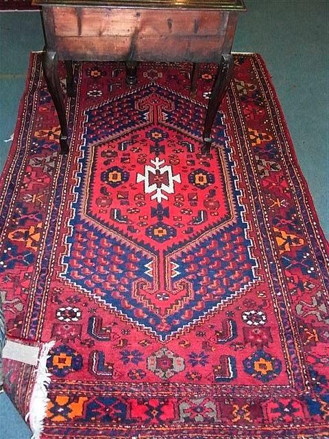 Appraisal: AN AFGHAN RED GROUND RUG with central medallion within a