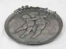 Appraisal: A circular pewter dish with putti and roses cm diameter