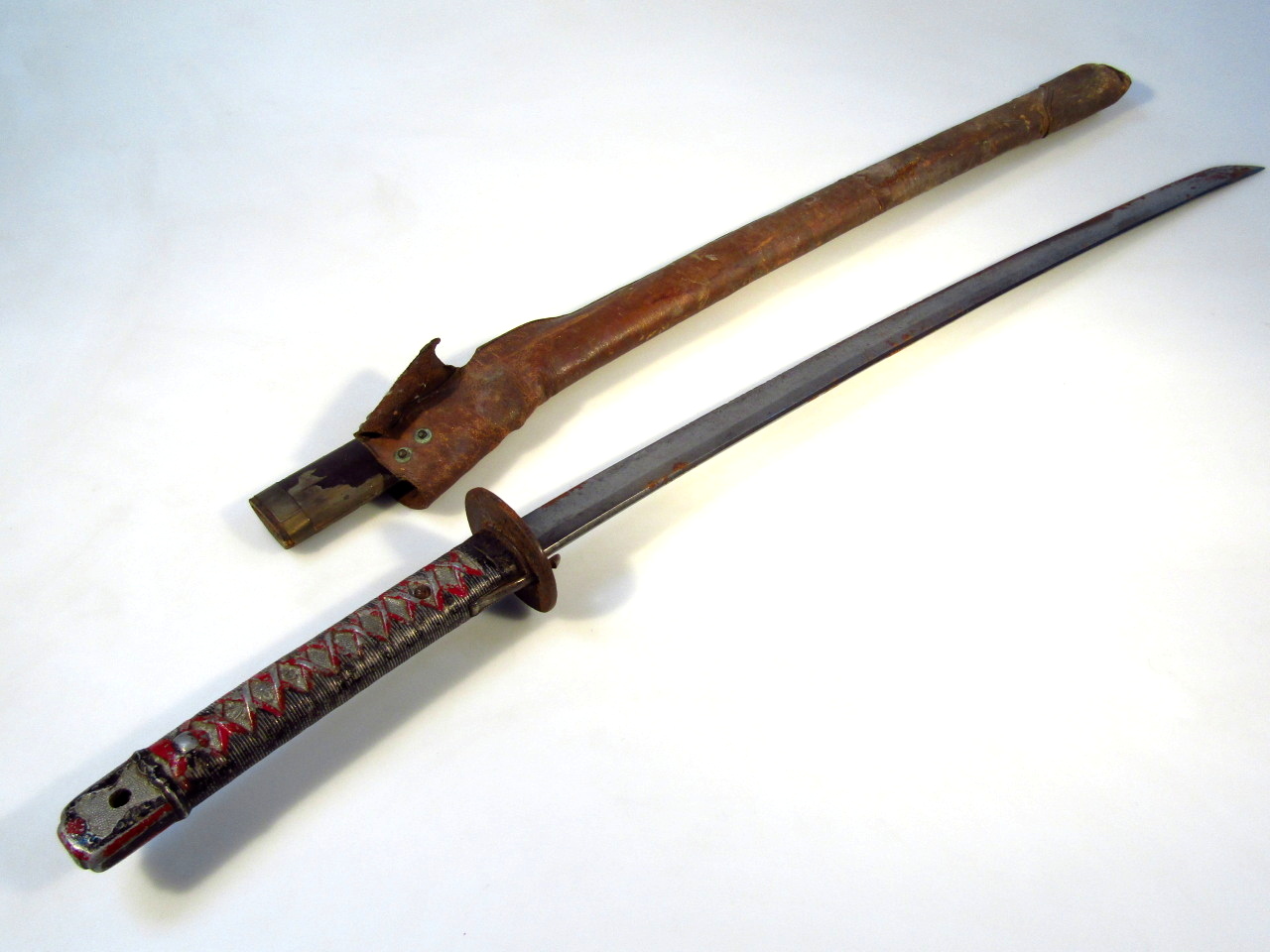 Appraisal: A thC Japanese Samurai sword with metal and leather scabbard