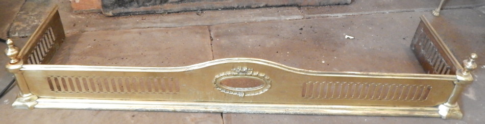 Appraisal: A thC pierced brass fender with turned urn finials and