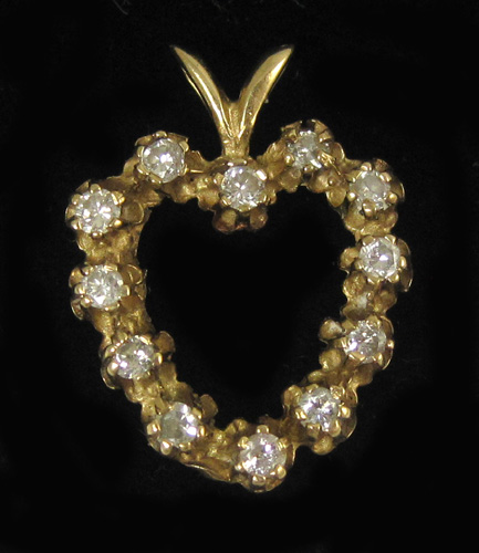 Appraisal: DIAMOND AND FOURTEEN KARAT GOLD PENDANT The open heart pendant