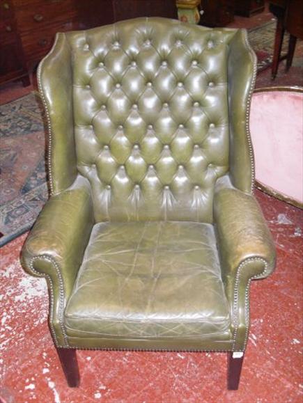 Appraisal: A George III style green leather wingback armchair