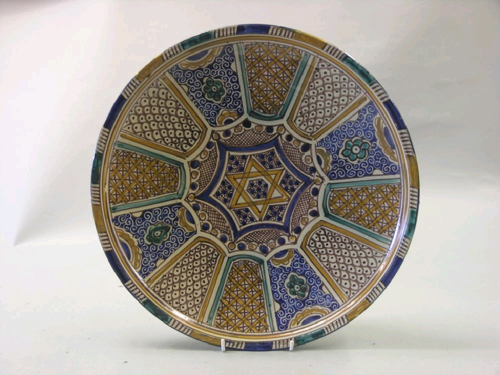 Appraisal: A large Arabic tin-glazed earthenware wall plate painted with geometric