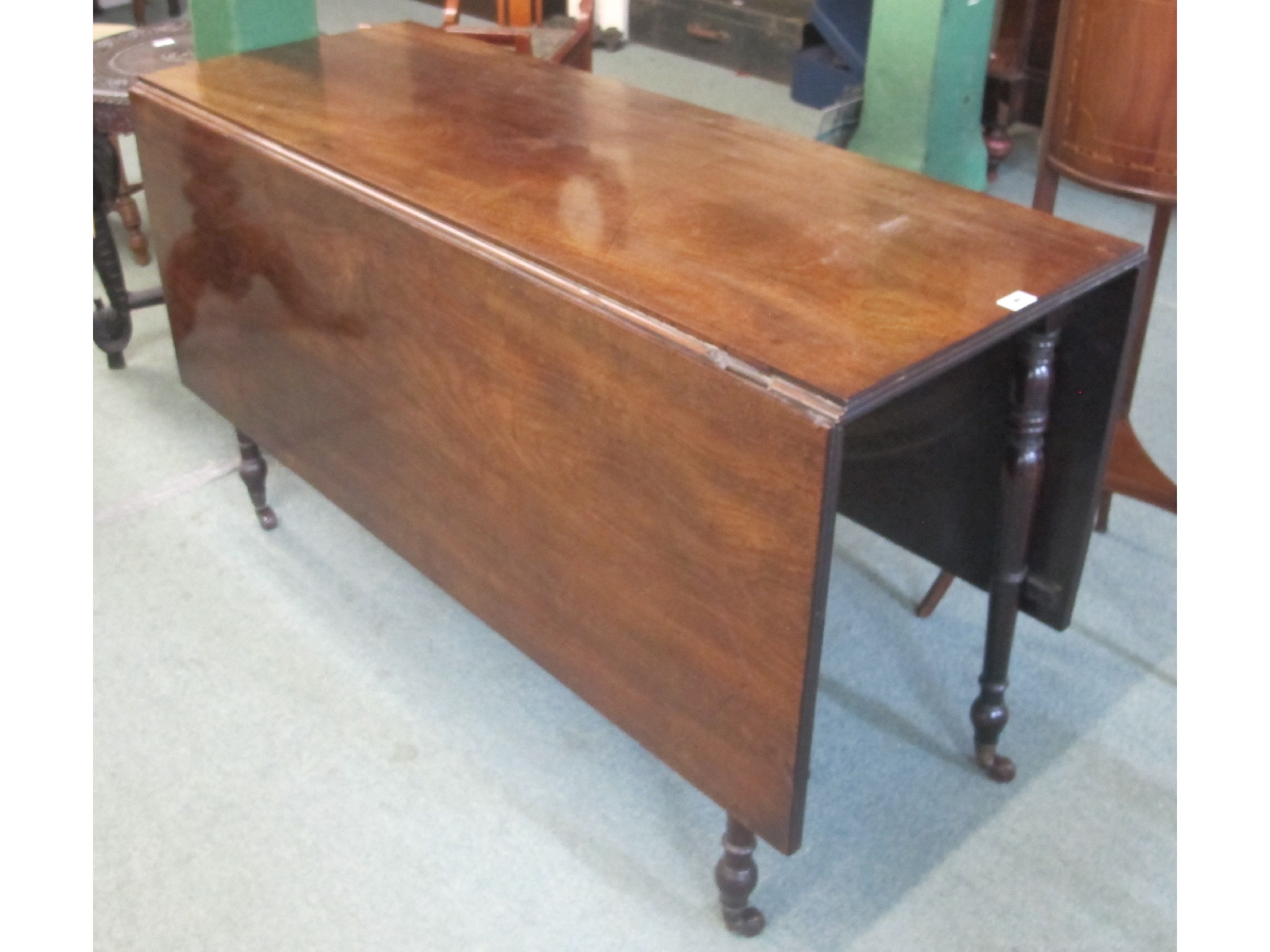 Appraisal: A th Century mahogany drop leaf table on turned tapering