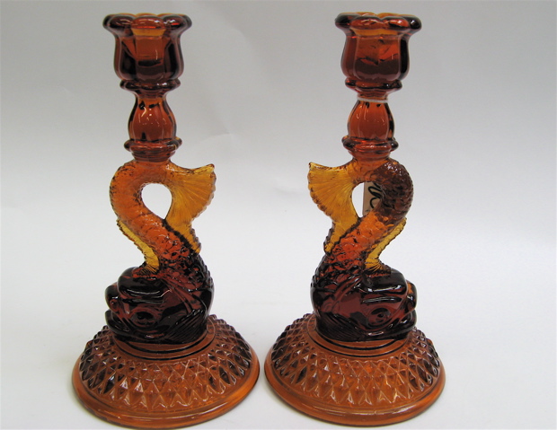 Appraisal: AMBER MOLDED GLASS FIGURAL DOLPHIN CANDLESTICKS raised on round base