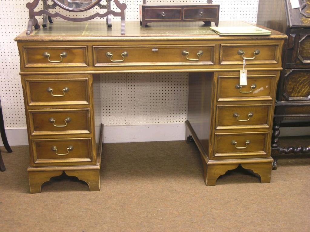 Appraisal: A reproduction yew-veneered pedestal desk inset gilt-tooled leather top above