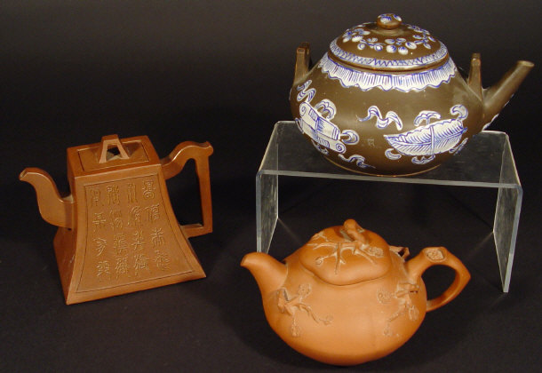 Appraisal: Three Oriental terracotta teapots relief moulded with flowers peony trees