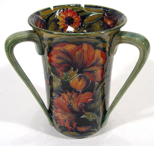 Appraisal: Moorcroft pottery three handled vase with hand painted and tubelined