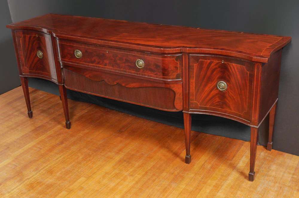 Appraisal: TH CENTURY MAHOGANY SERPENTINE SIDEBOARD Banded mahogany veneer serpentine top