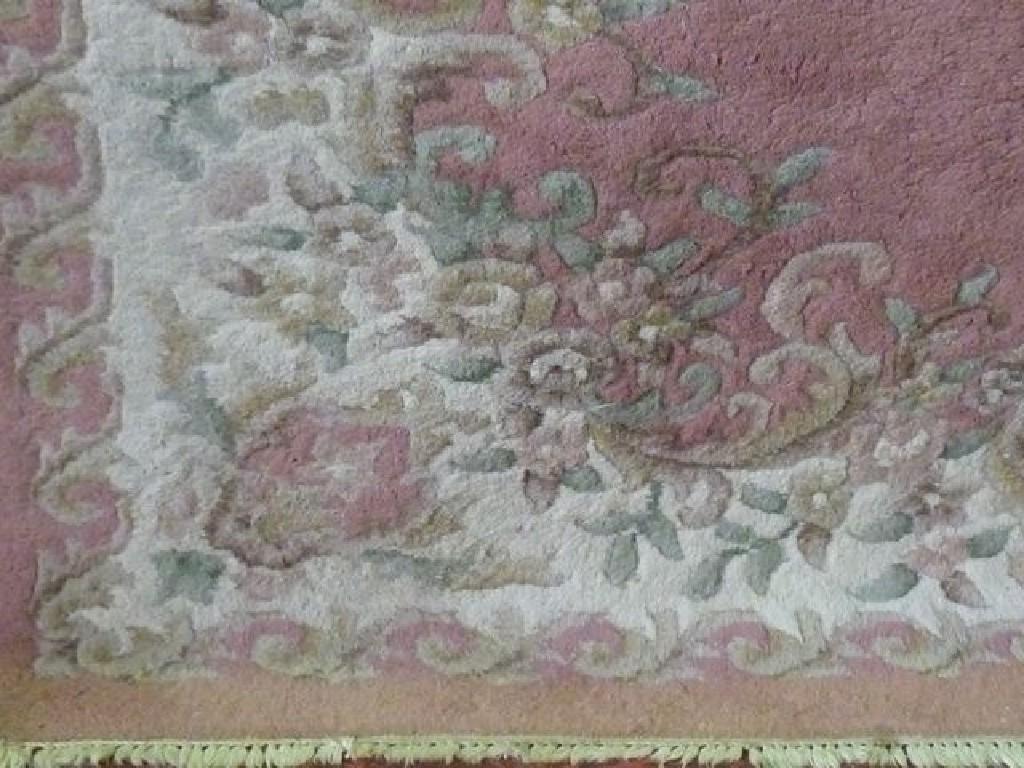 Appraisal: An Indian wool carpet with pink field and floral decoration