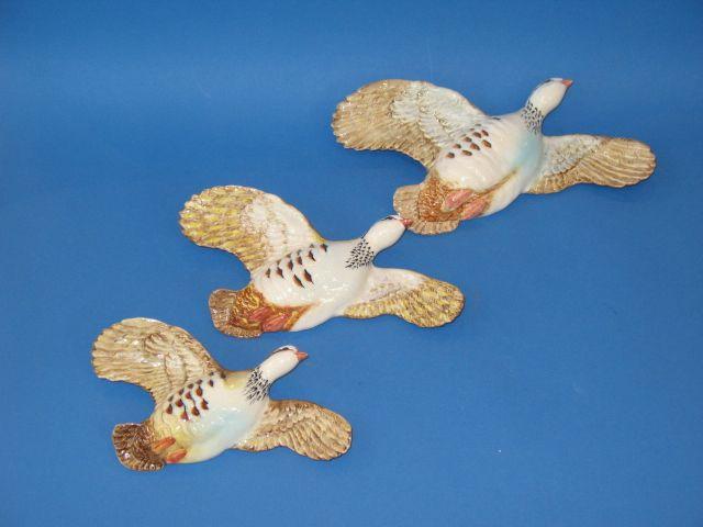 Appraisal: A GRADUATED SET OF THREE BESWICK WALL MOUNTED FLIGHTING PARTRIDGES