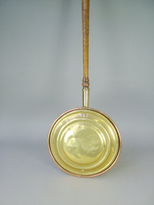 Appraisal: A copper brass warming pan fitted with turned wooden long