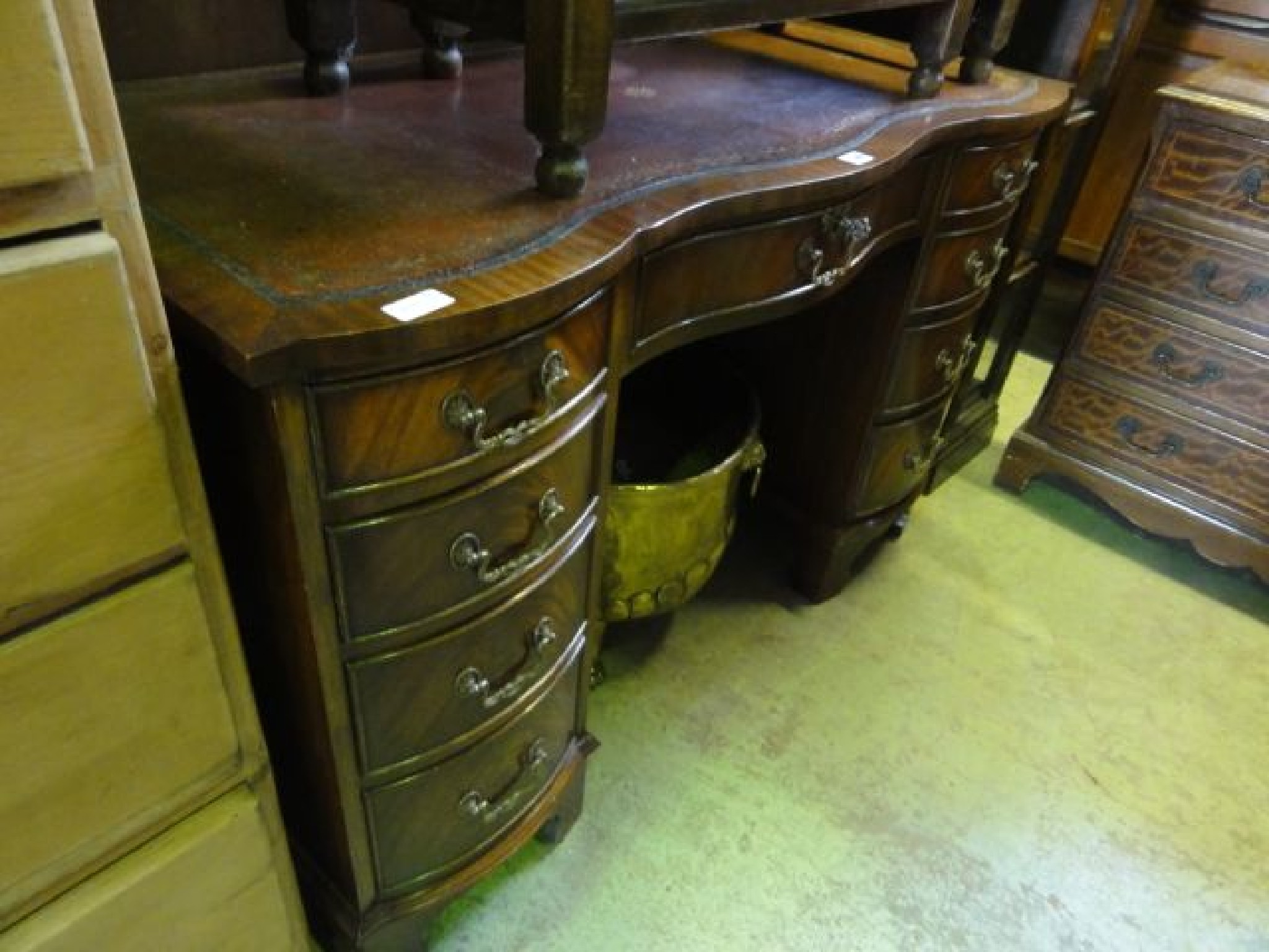 Appraisal: A reproduction mahogany kneehole pedestal desk with serpentine front and