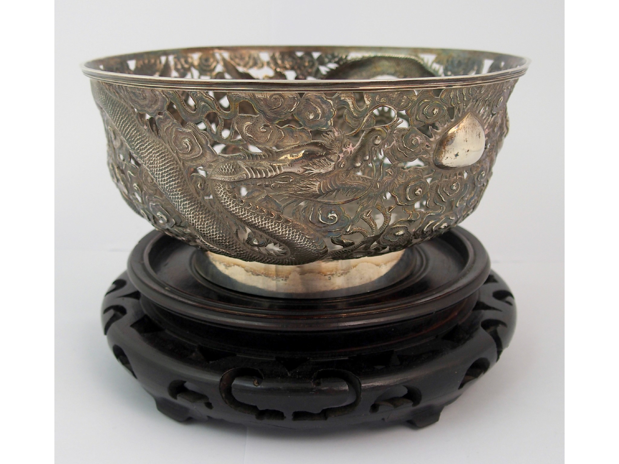 Appraisal: A Chinese silver bowlcast with dragons and cloud scrolls divided