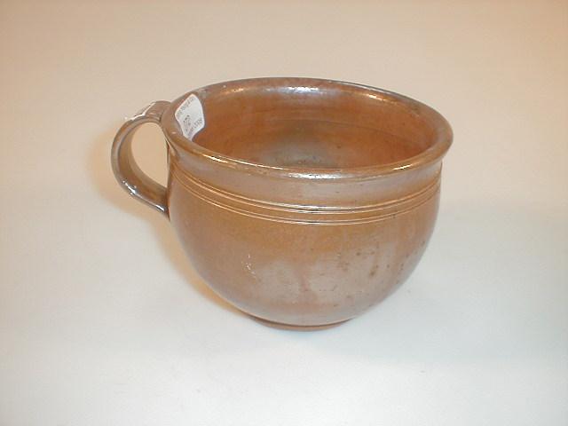 Appraisal: A thC saltglaze potty with a reeded handle and with