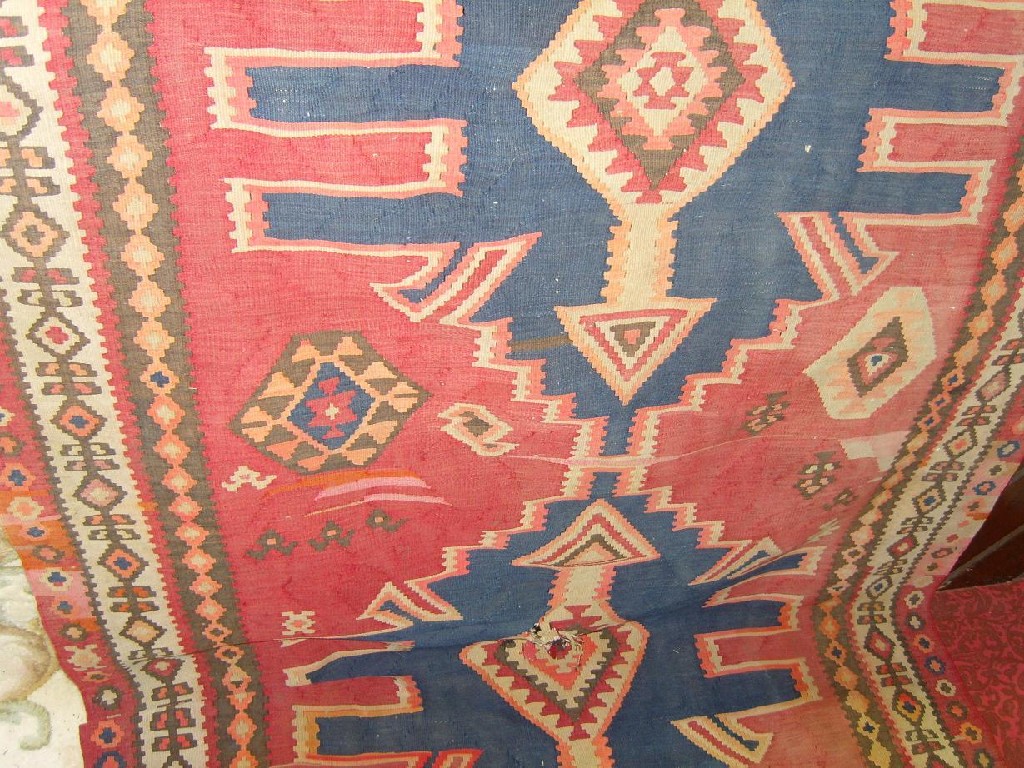 Appraisal: A red ground eastern flat woven runner with geometric decoration