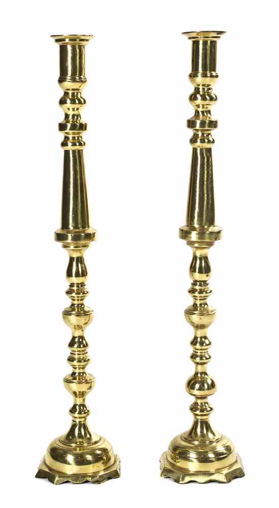 Appraisal: A Pair of Brass Candlesticks each having a shaped and