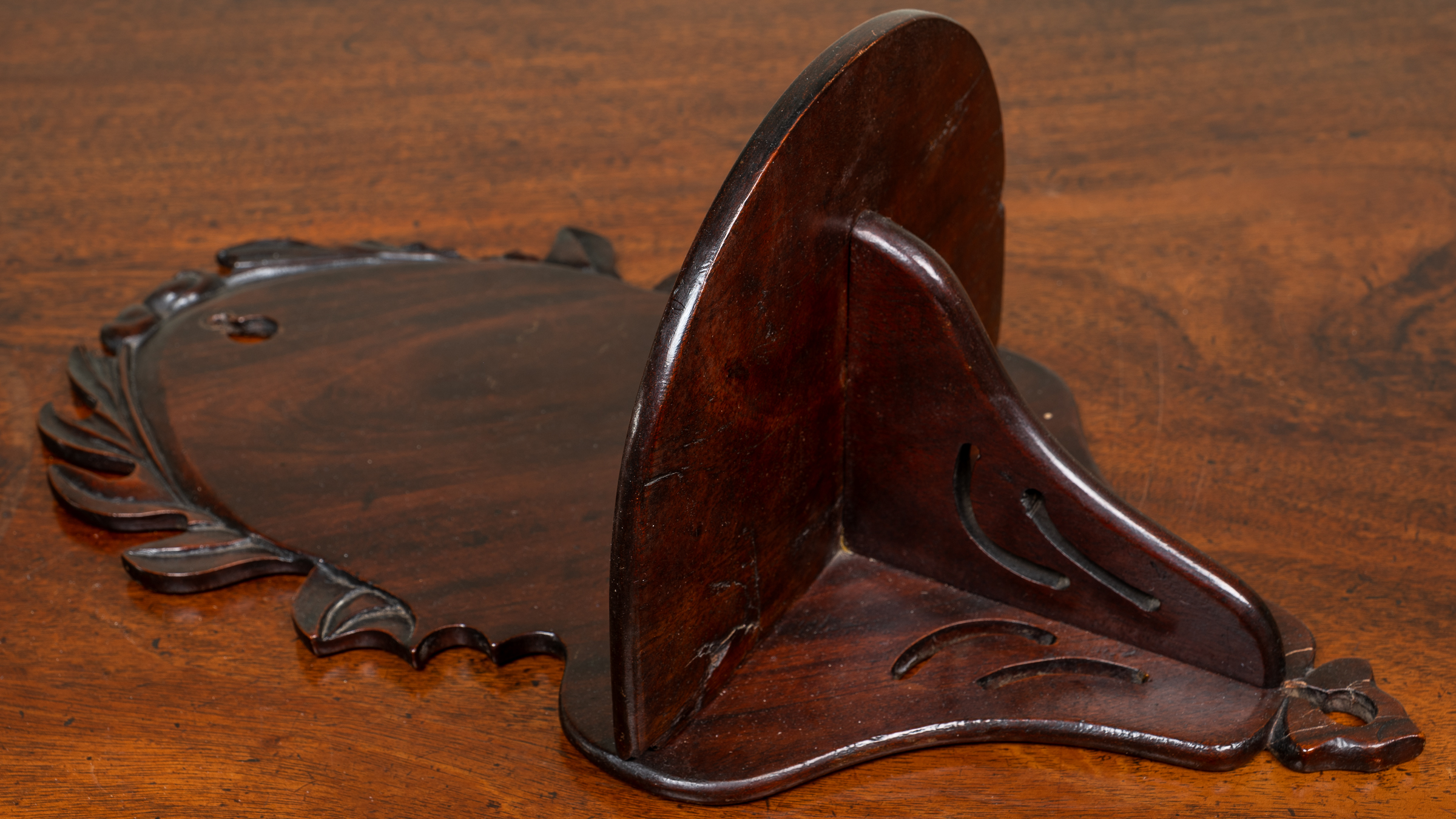 Appraisal: A mahogany wall bracket with decoratively cast and pierced decoration