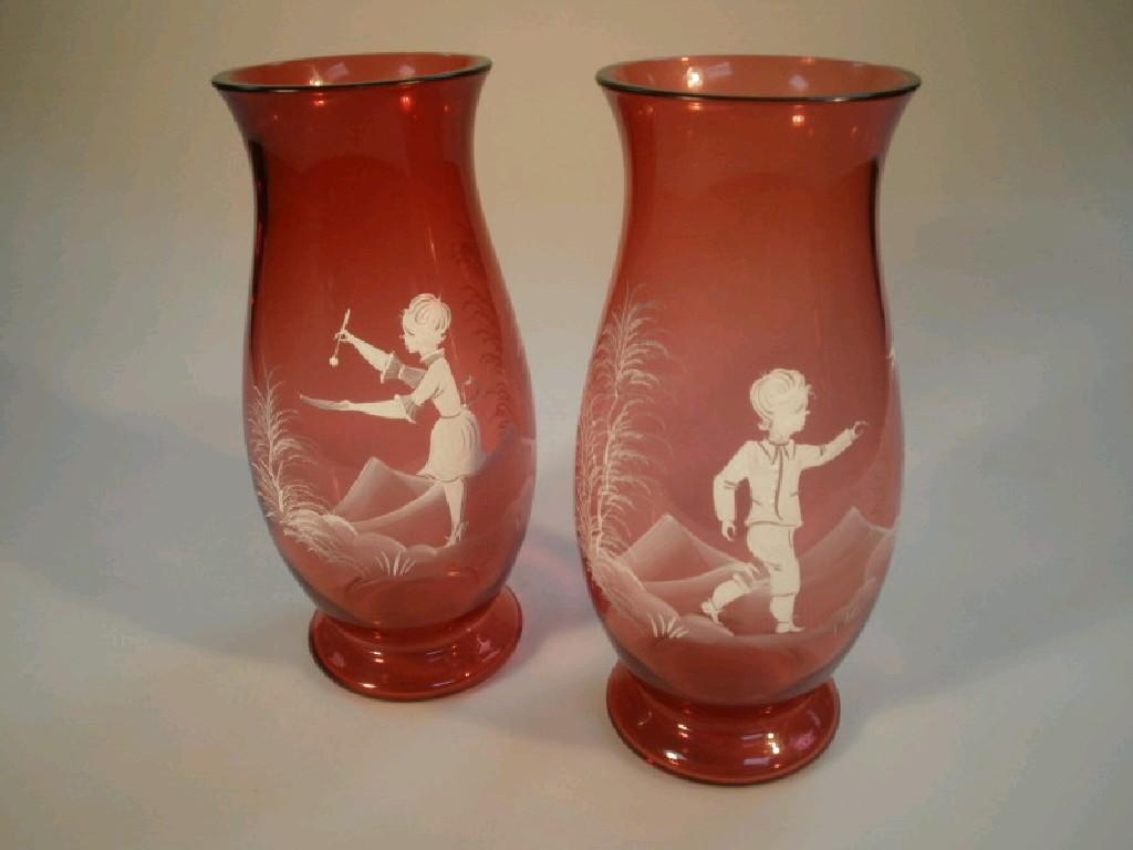 Appraisal: A pair of Mary Gregory style cranberry glass vases decorated