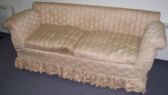 Appraisal: An upholstered settee with scroll arms raised on turned legs