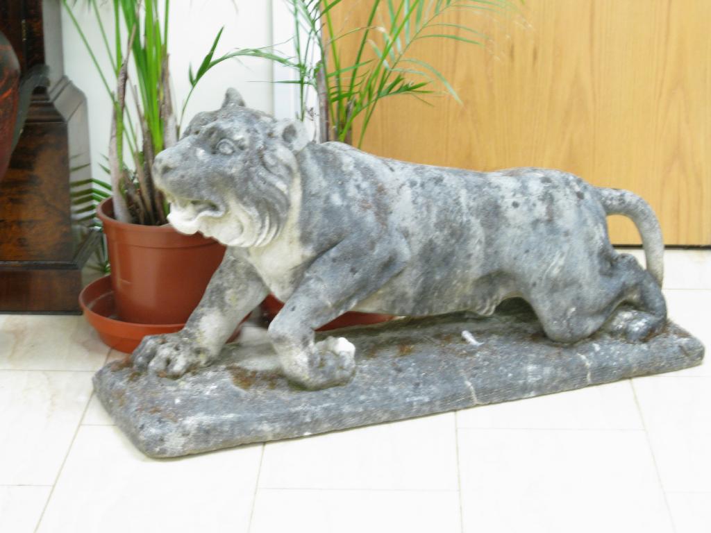 Appraisal: A simulated stone Prowling Lion on rectangular base ft in