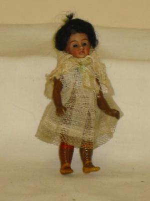 Appraisal: A Mulatto bisque doll's house doll with fixed blue glass