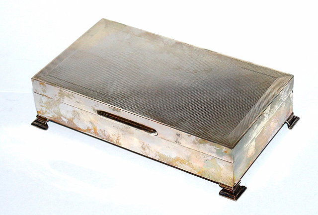 Appraisal: A RECTANGULAR SILVER CIGARETTE BOX with engine engraved hinged lid