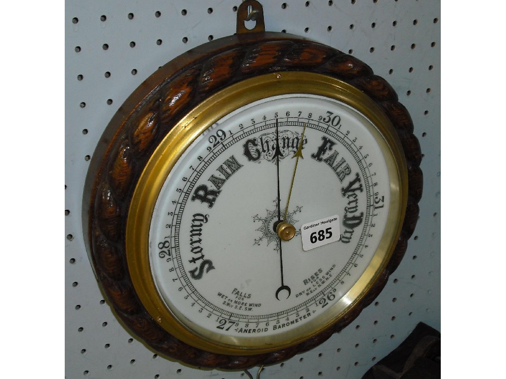 Appraisal: Oak aneroid circular barometer the white dial within a rope