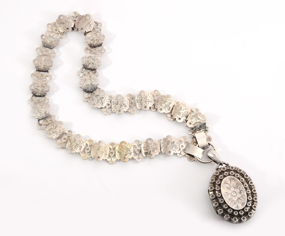 Appraisal: A VICTORIAN SILVER LOCKET CHAIN Oval floral embossed and star