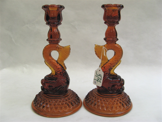 Appraisal: AMBER MOLDED GLASS FIGURAL DOLPHIN CANDLESTICKS raised on round base