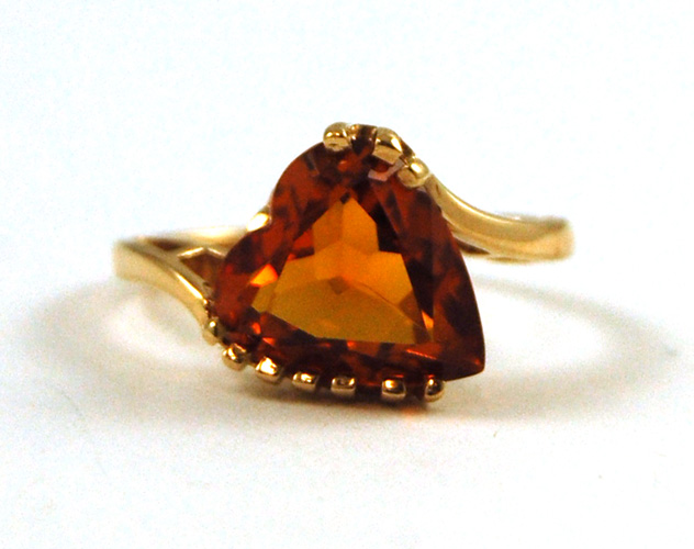 Appraisal: ORANGE SAPPHIRE AND TEN KARAT GOLD RING set with a