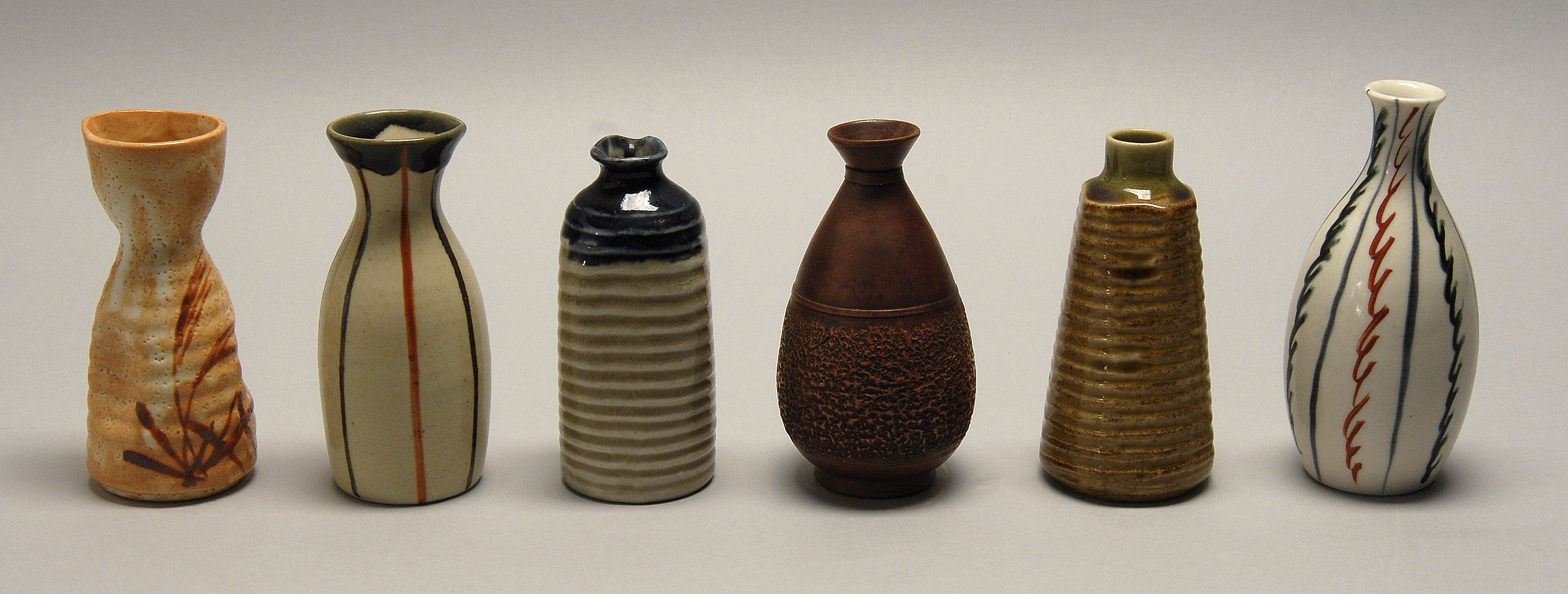 Appraisal: SIX POTTERY SAKE BOTTLES Pear shape with brown glaze red